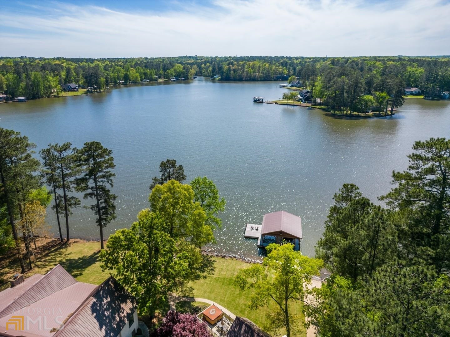 an aerial view of a residential houses with outdoor space and lake view