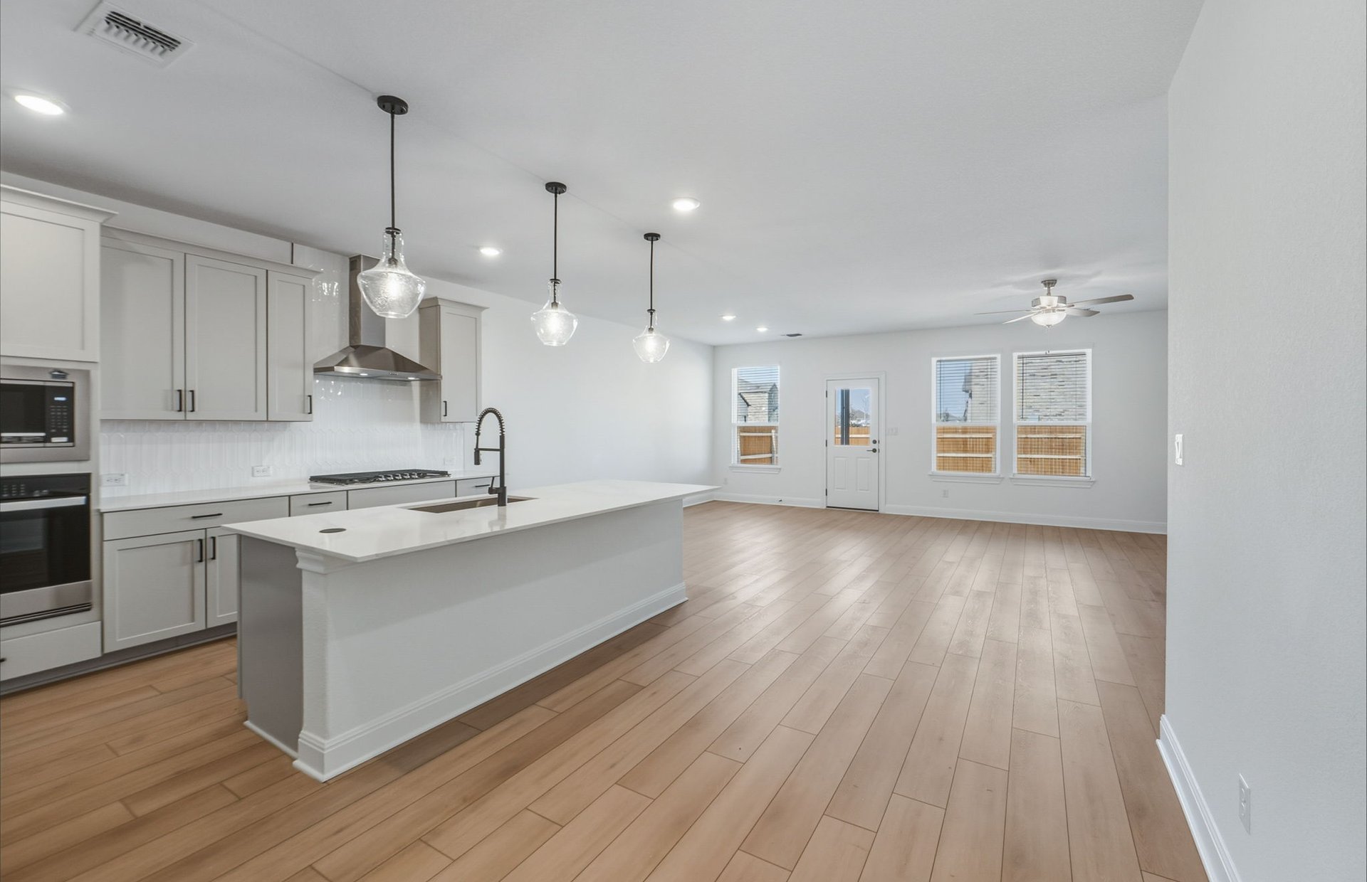 16800 Catemaco Walk Manor Manor, TX 78653 - Photo 3 of 26 a large kitchen with cabinets wooden floor and stainless steel appliances