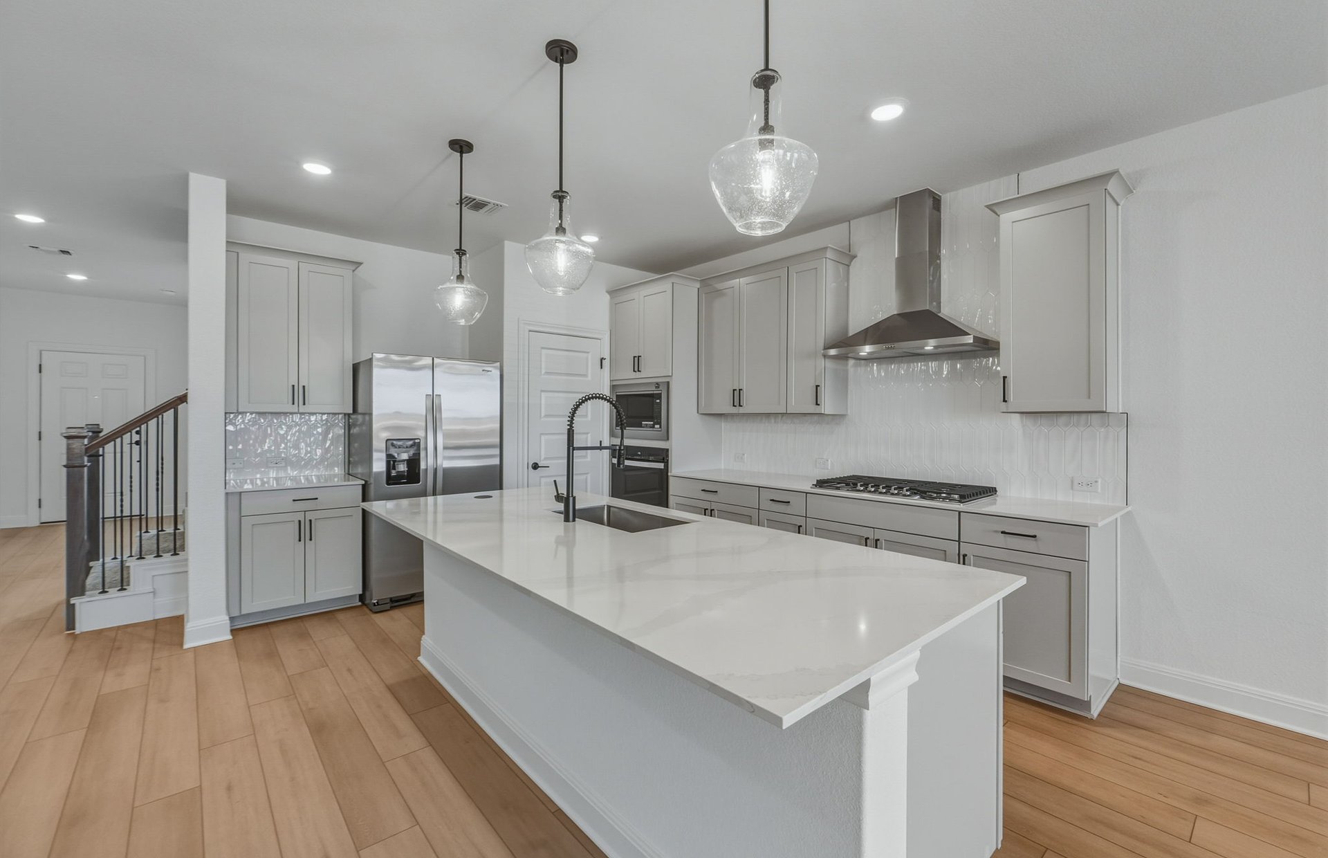 16800 Catemaco Walk Manor Manor, TX 78653 - Photo 4 of 26 a large kitchen with stainless steel appliances a large counter top a stove a refrigerator and a view of living room