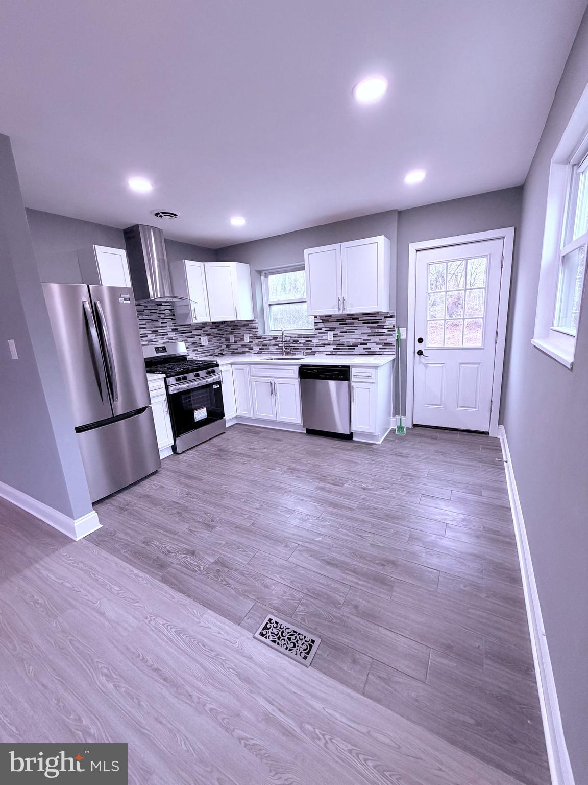 3507 Riviera Street Temple Hills, MD 20748 - Photo 3 of 16 a large kitchen with kitchen island a stove a sink a refrigerator wooden floor and cabinets