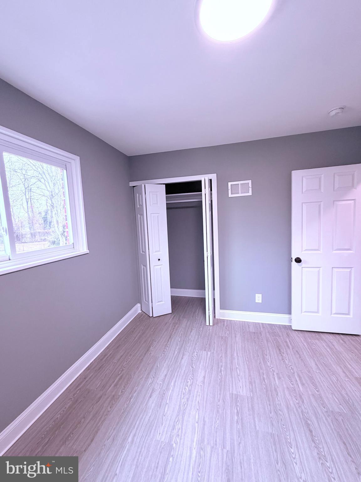 3507 Riviera Street Temple Hills, MD 20748 - Photo 6 of 16 a view of an empty room with window and wooden floor