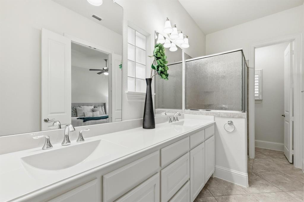 516 Sandy Lane Flower Mound, TX 75022 - Photo 18 of 38 Double vanity with white cabinetry, integrated sinks, chrome fixtures, and a spacious countertop