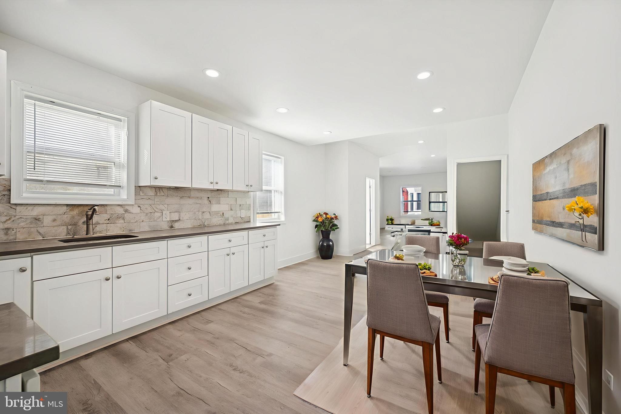 2135 North 20th Street Philadelphia, PA 19121 - Photo 4 of 20 a kitchen with stainless steel appliances granite countertop a table chairs sink and cabinets