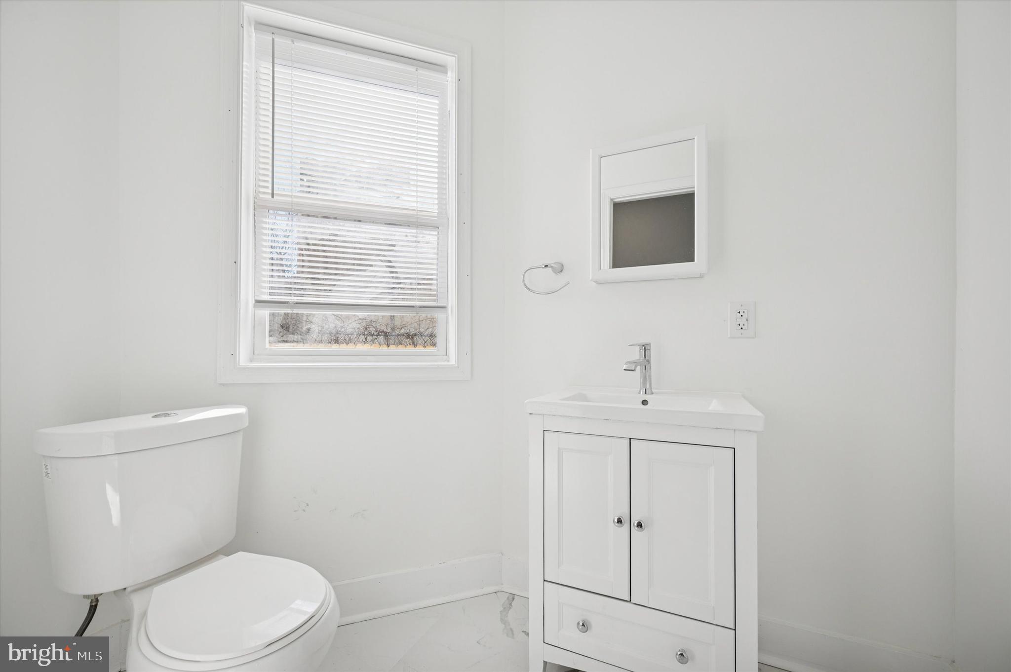 2135 North 20th Street Philadelphia, PA 19121 - Photo 8 of 20 a bathroom with a toilet a sink a window and mirror
