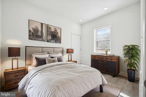 a bedroom with a large bed and a potted plant