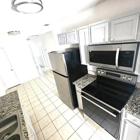 a kitchen with granite countertop a stove and a microwave