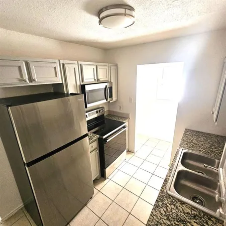 a kitchen with granite countertop a refrigerator and a stove