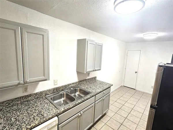 a kitchen with granite countertop a stove and a refrigerator