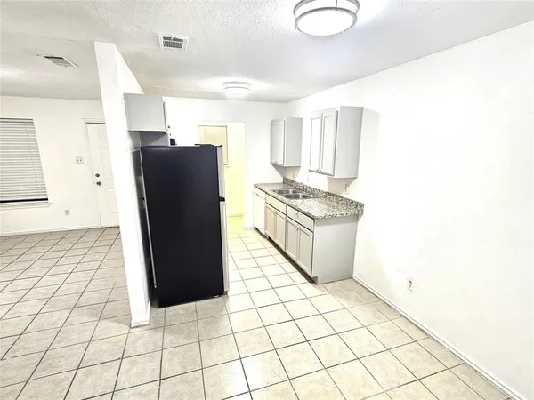 a kitchen with a stove a refrigerator and cabinets