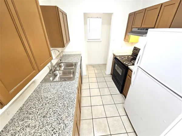 a view of a storage & utility room with fridge and wooden floor