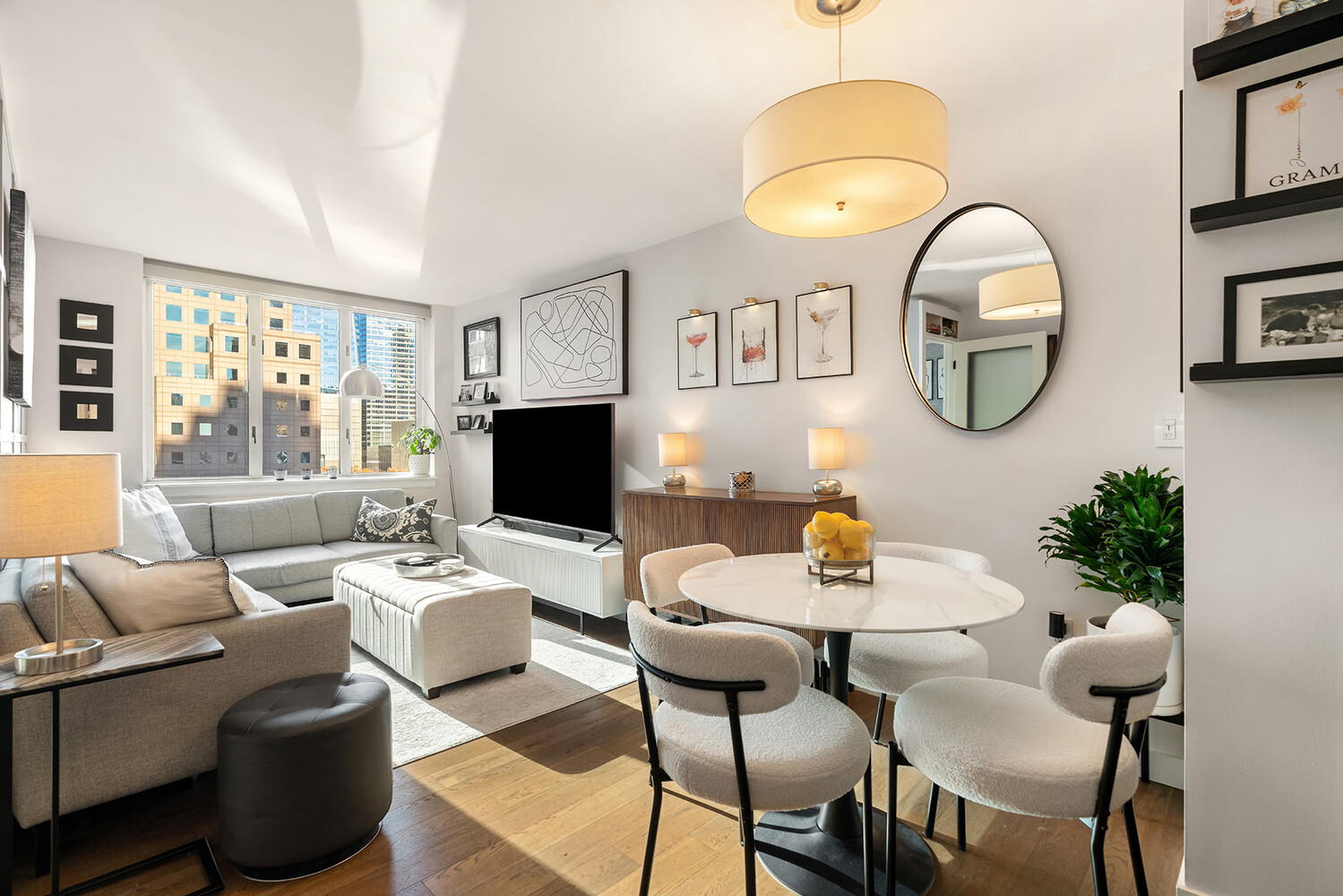 225 Rector Place, Unit 9B Manhattan, NY 10280 - Photo 1 of 14 a living room with furniture a mirror and a flat screen tv