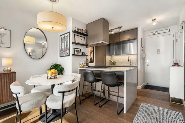 a kitchen with a dining table cabinets and stainless steel appliances