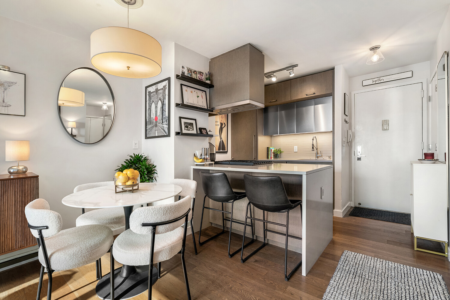225 Rector Place, Unit 9B Manhattan, NY 10280 - Photo 3 of 14 a kitchen with a dining table cabinets and stainless steel appliances