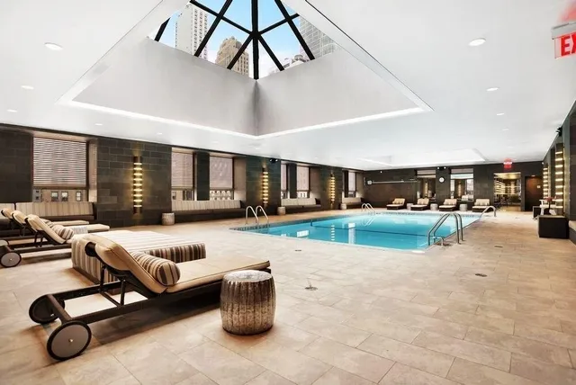 a living room with furniture a flat screen tv and a large window