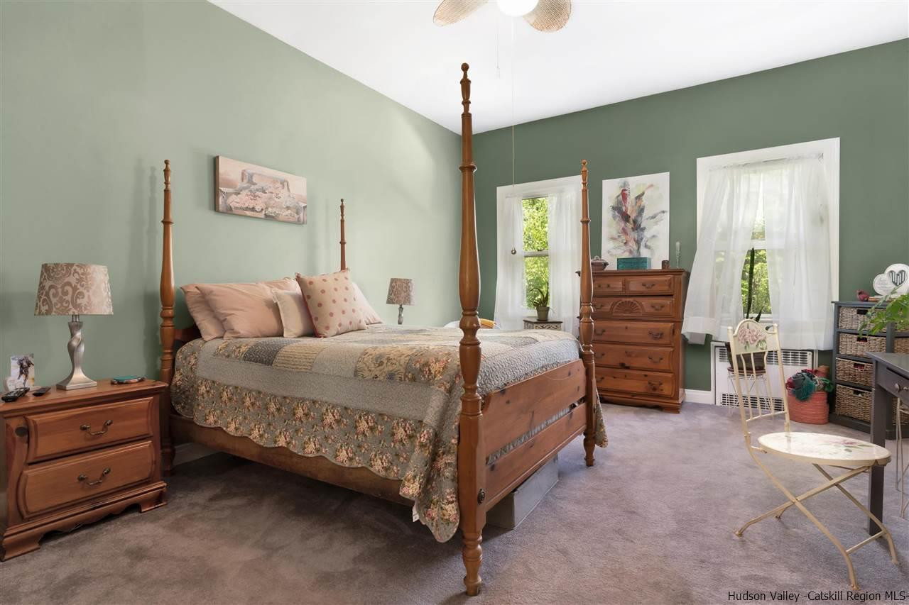 295 Game Farm Road Catskill, NY 12414 - Photo 25 of 35 a bedroom with a bed and a chandelier