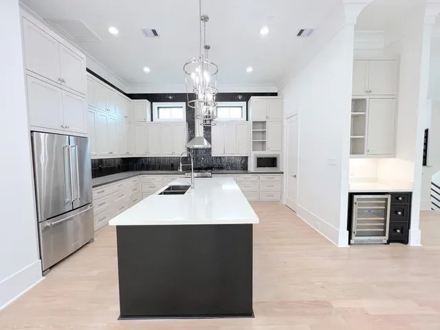 a large kitchen with a large counter top stainless steel appliances and cabinets
