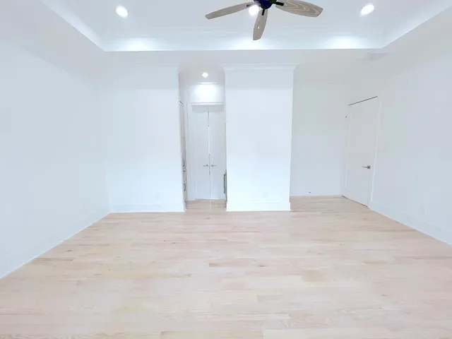 a view of an empty room with a window and a ceiling fan
