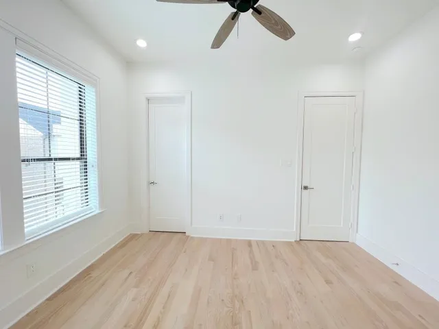 an empty room with a window and a fan