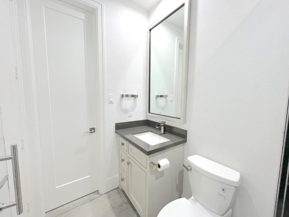 2122 Blalock Road, Unit B Houston, TX 77080 - Photo 40 of 45 a bathroom with a granite countertop sink toilet and a mirror