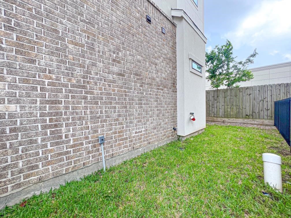 2122 Blalock Road, Unit B Houston, TX 77080 - Photo 41 of 45 a view of a backyard with brick wall and potted plants