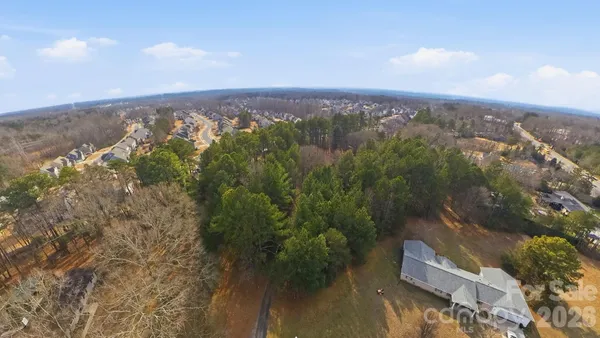 an aerial view of house with yard and mountain view in back