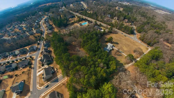 an aerial view of residential houses with outdoor space and trees