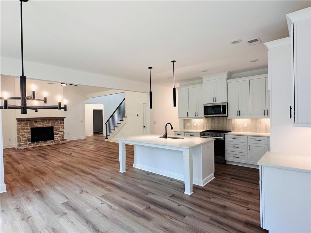 6312 Woodstock Road Acworth, GA 30102 - Photo 11 of 44 a large kitchen with cabinets wooden floor and stainless steel appliances
