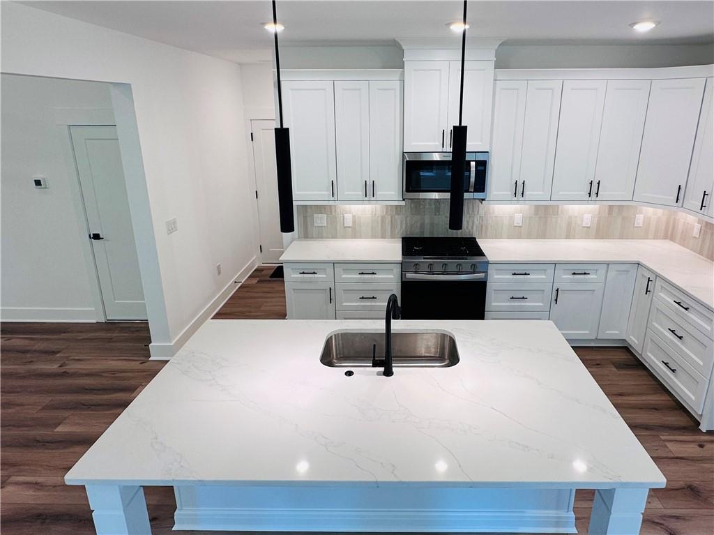 6312 Woodstock Road Acworth, GA 30102 - Photo 12 of 44 a kitchen with kitchen island granite countertop a stove and a sink