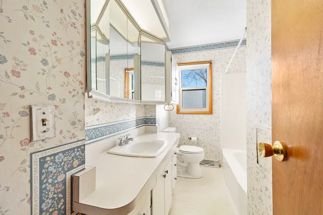 a bathroom with a sink a toilet and mirror