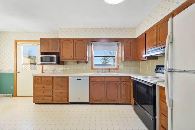a kitchen with stainless steel appliances granite countertop a stove a sink and a refrigerator