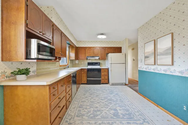 a kitchen with stainless steel appliances granite countertop a refrigerator sink and cabinets