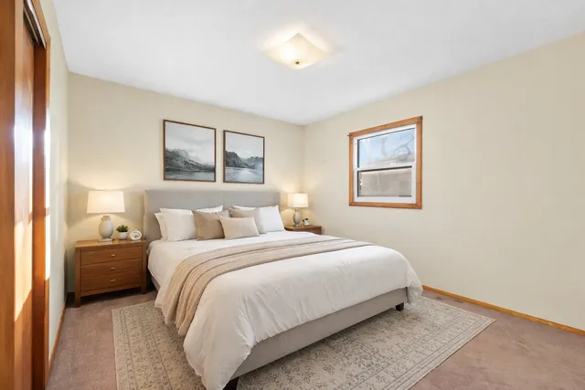 a bedroom with a bed and a painting on the wall