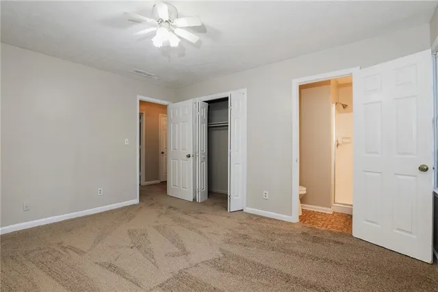 a view of an empty room and chandelier fan