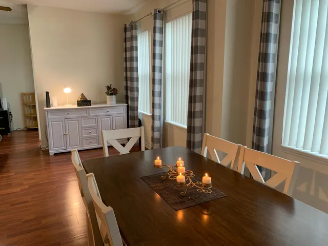 a living room with furniture two window and wooden floor