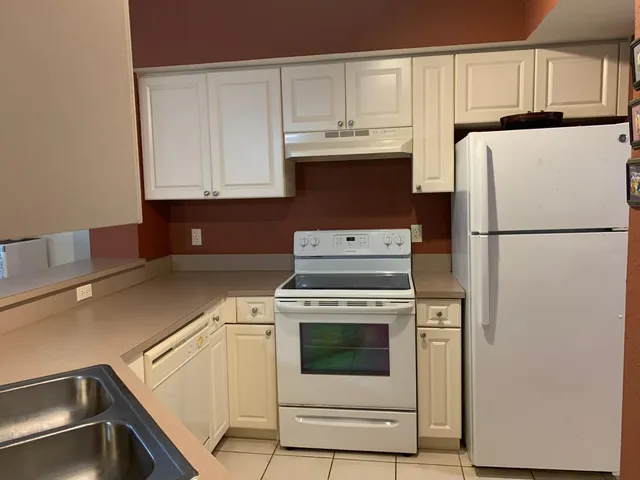 a kitchen with a refrigerator sink and cabinets