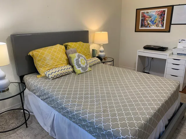 a bedroom with a bed and painting on the wall