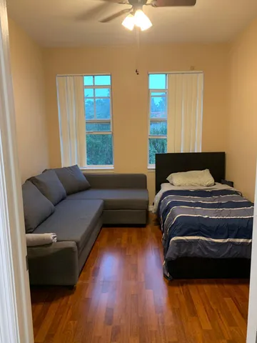 a bedroom with a bed couch and window