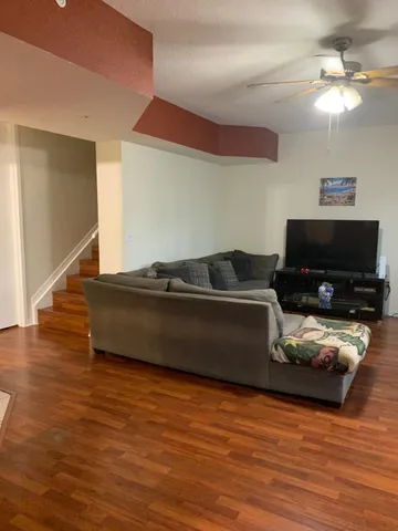 a living room with furniture and a wooden floor
