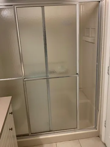 a bathroom with a glass shower door
