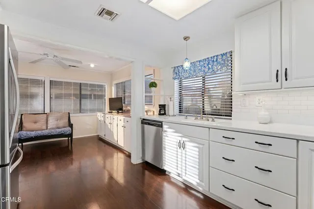 a kitchen with stainless steel appliances a refrigerator sink and cabinets