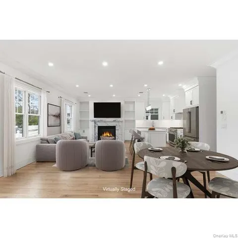 a living room with furniture a flat screen tv and kitchen view