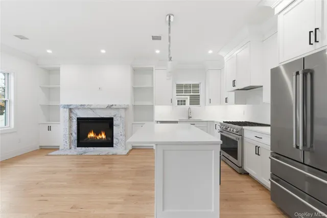 a kitchen with a refrigerator and a fireplace