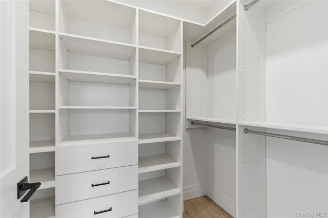 a kitchen with stainless steel appliances granite countertop a wooden floors and white walls