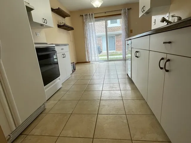 a kitchen with a refrigerator a stove top oven and a counter top space
