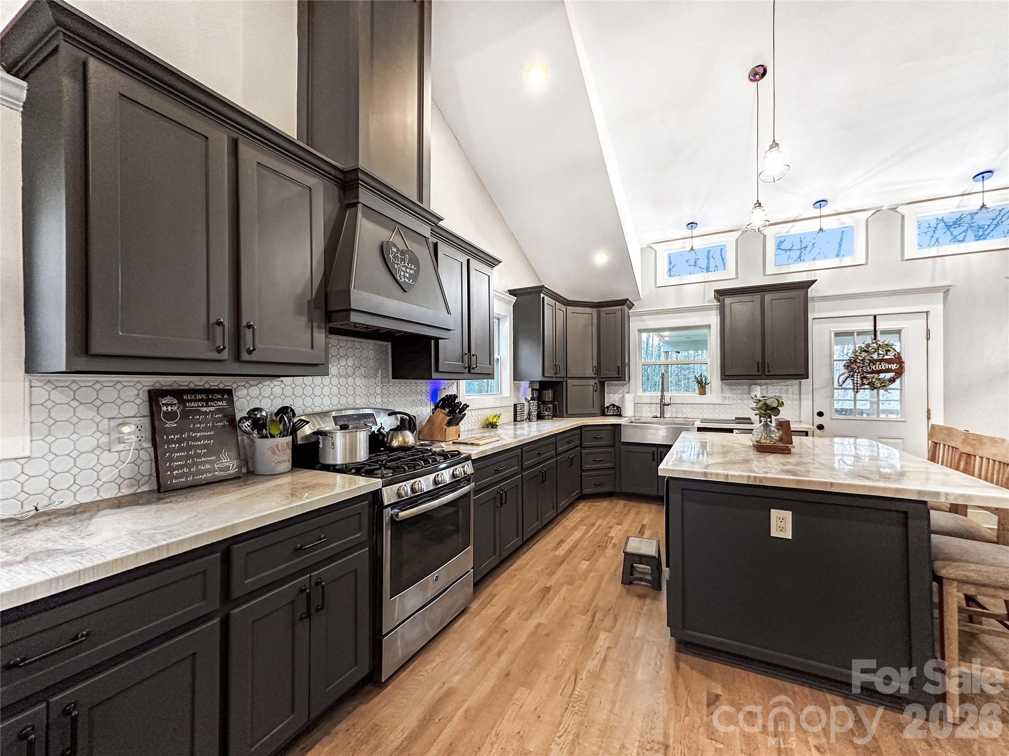 4386 Rocky Road Lenoir, NC 28645 - Photo 26 of 43 a kitchen with stainless steel appliances granite countertop a sink stove and wooden cabinets