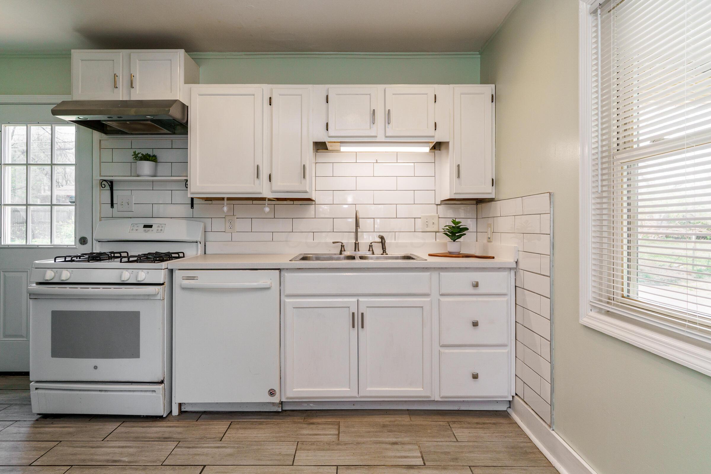 805 Exeter Road Whitehall, OH 43213 - Photo 5 of 28 The kitchen features a subway tile surround and complementary white cabinetry.