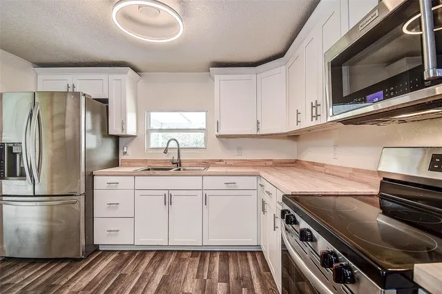 a kitchen with a sink stove and microwave