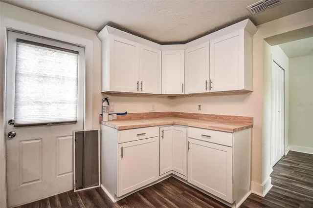 a kitchen with granite countertop white cabinets and white appliances