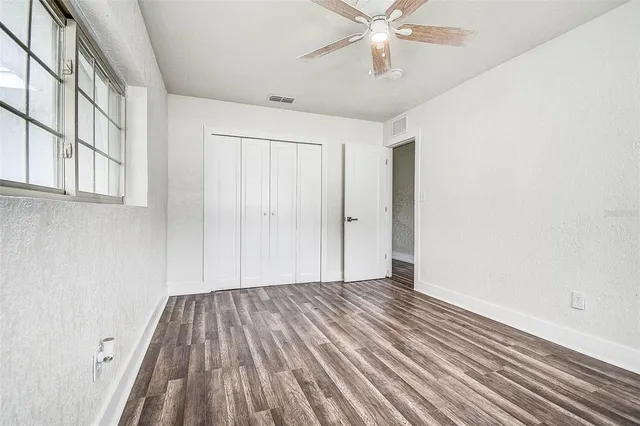 a view of a room with wooden floors and fan