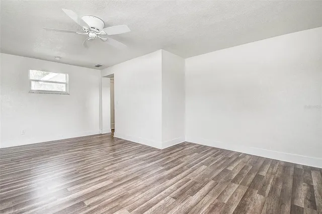a view of an empty room with wooden floor